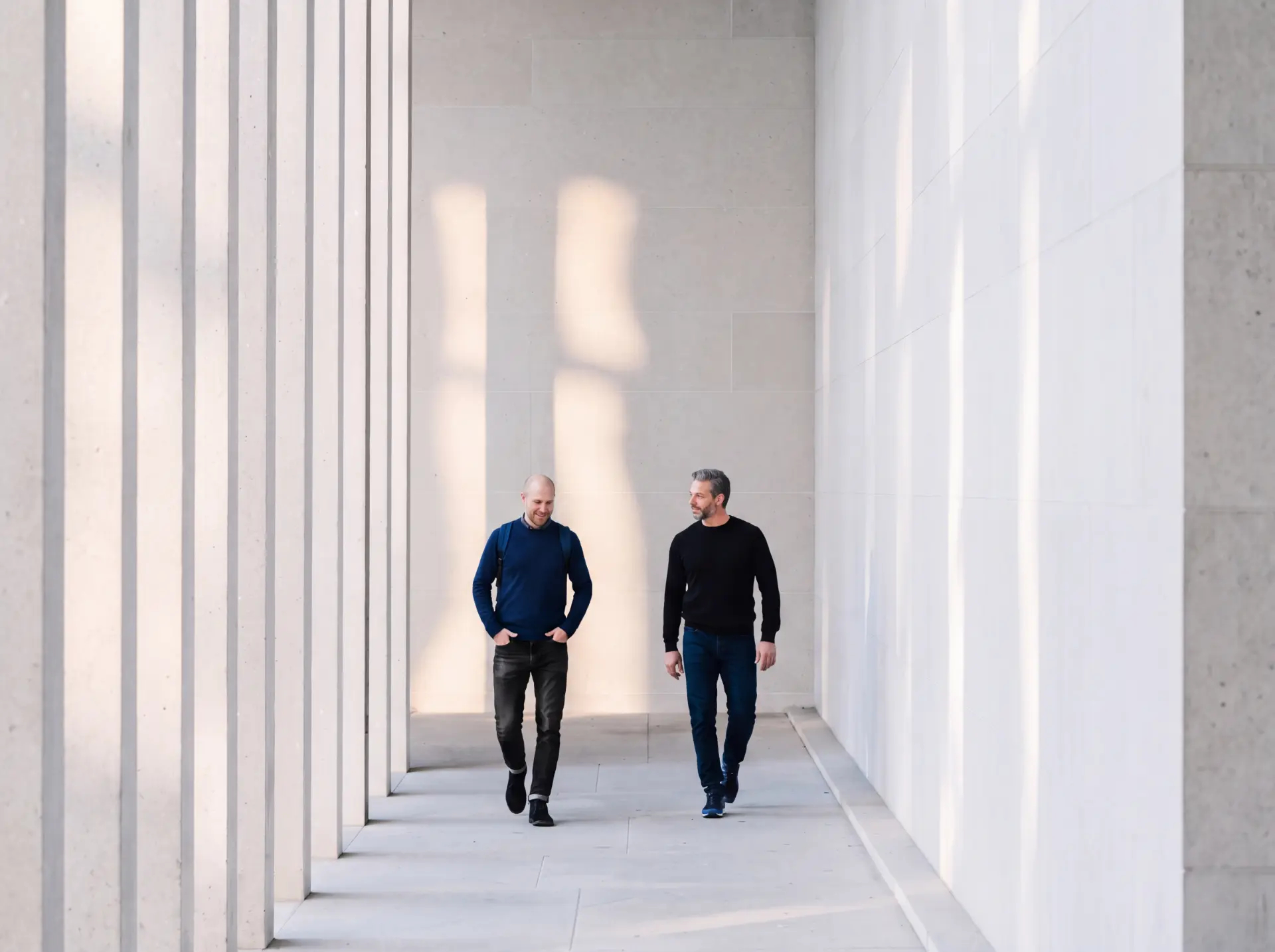 Two business professionals walking through a bright modern corridor